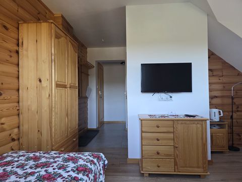 Apartament — drewniana szafa, wejście z przedpokoju i telewizor