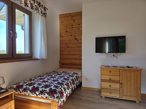 Pokój 1 — łóżko pojedyncze, komoda i telewizor